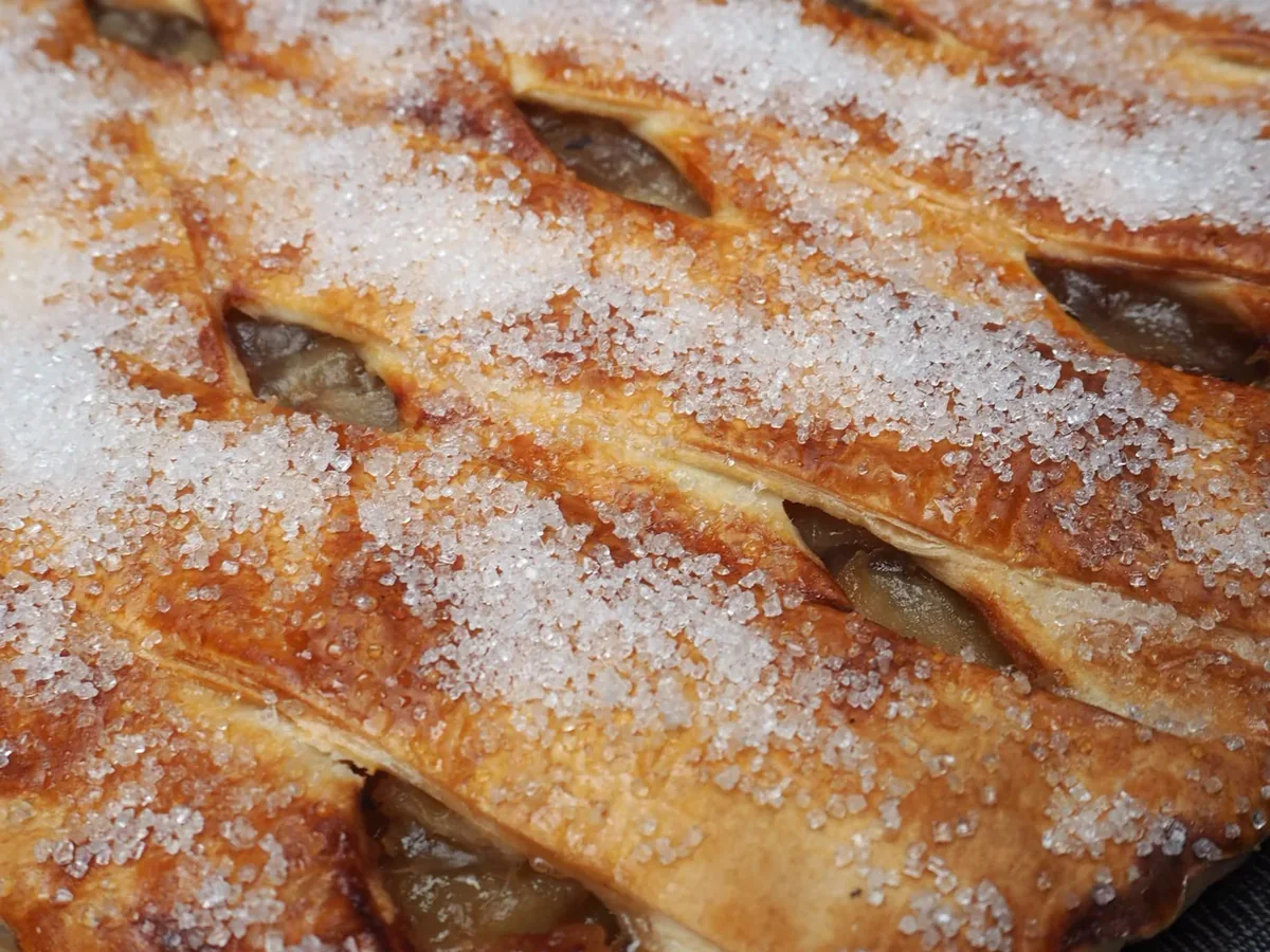 A lattice fruit pie under a crust of sugar.